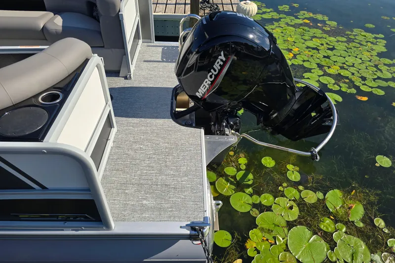 Slide: The Image of 2025 Premier 230 SunSation RF pontoon boat with Mercury engine on a lake. - 10