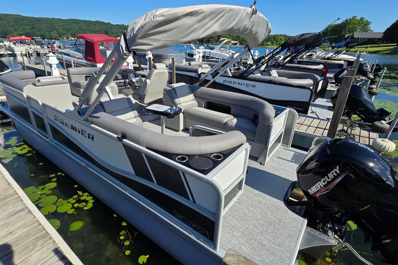 Slide: The Image of 2025 Premier 230 SunSation RF pontoon boat docked, featuring spacious seating and Mercury outboard motor. - 11