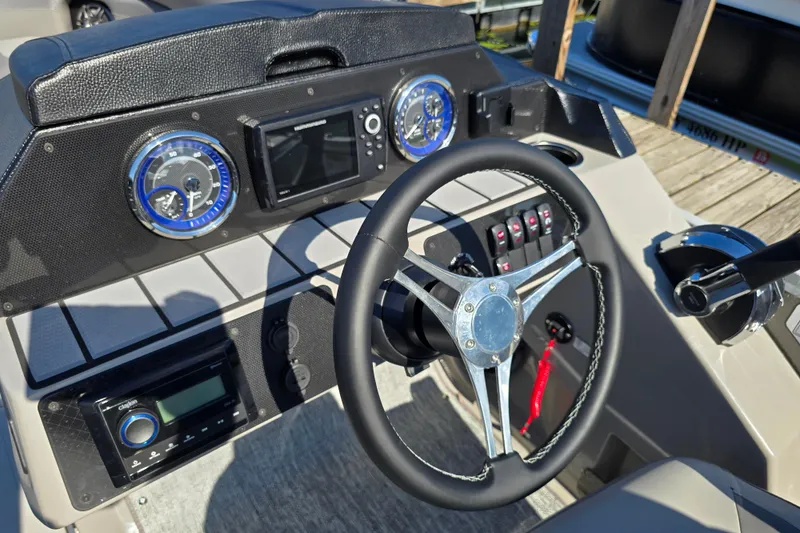 Slide: The Image of 2025 Premier 230 SunSation RF boat dashboard with steering wheel and control panel. - 16