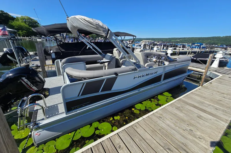 Slide: The Image of 2025 Premier 230 SunSation RF pontoon boat docked at a marina on a sunny day. - 3