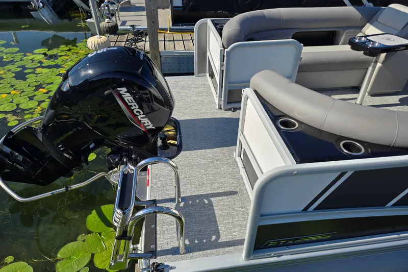 Slide: The Image of 2025 Premier 230 SunSation RF pontoon boat with Mercury engine, docked near lily pads. - 4