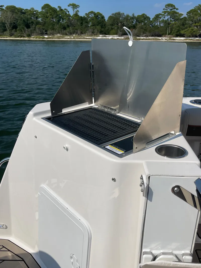 Slide: The Image of Outdoor grill on 2026 Cutwater C-288 Coupe boat, set against a scenic water backdrop. - 22