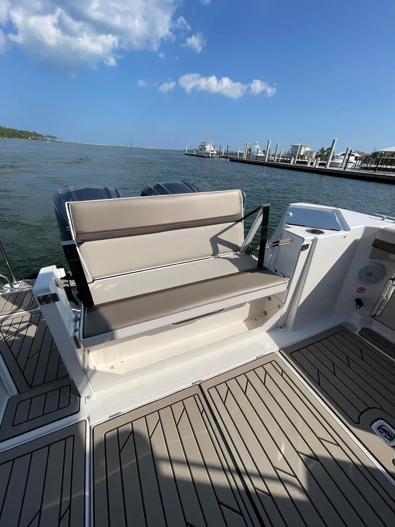 Slide: The Image of 2026 Cutwater C-288 Coupe boat deck with seating, overlooking marina and blue sky. - 25