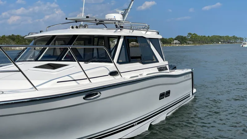 Slide: The Image of 2026 Cutwater C-288 Coupe boat on calm water, clear sky background. - 6