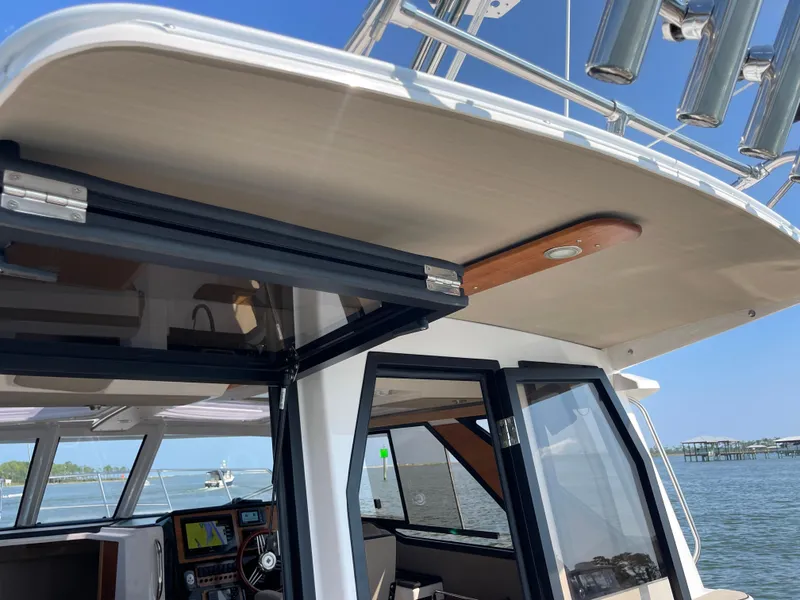 Slide: The Image of 2026 Cutwater C-288 Coupe boat with open cabin door, showcasing interior and ocean view. - 9