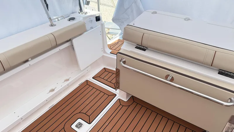 Slide: The Image of 2026 Ranger Tugs R-27 boat interior with tan seating and wood-patterned flooring. - 6
