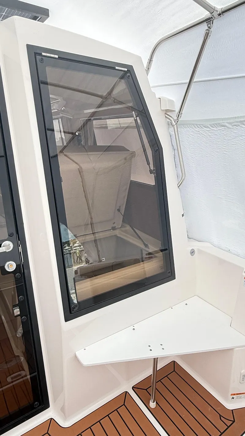 Slide: The Image of 2026 Ranger Tugs R-27 boat interior with sleek window and wooden flooring. - 10