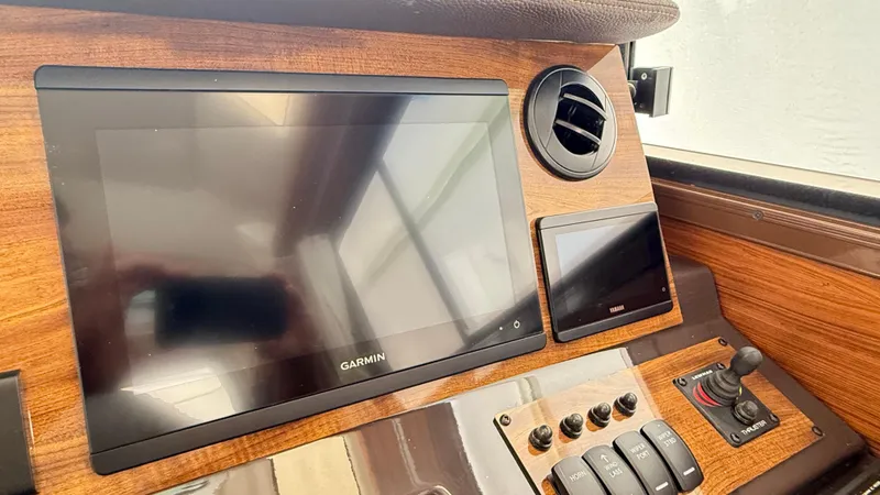 Slide: The Image of 2026 Ranger Tugs R-27 dashboard with Garmin display and control panel. - 24