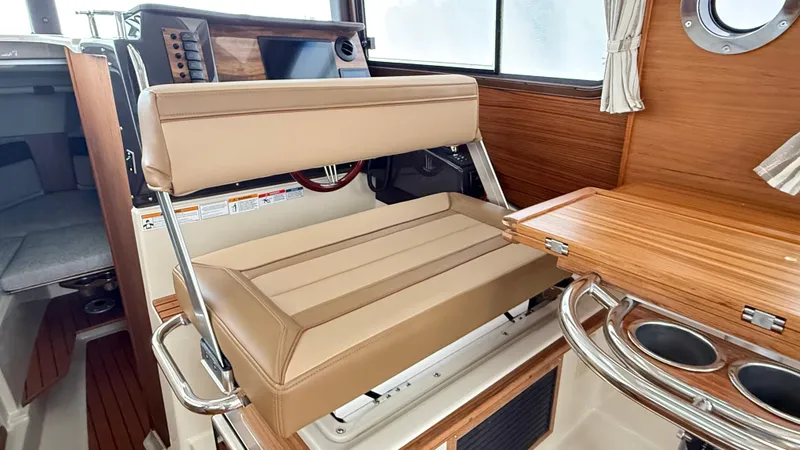 Slide: The Image of 2026 Ranger Tugs R-27 interior with beige seating and wooden accents. - 30