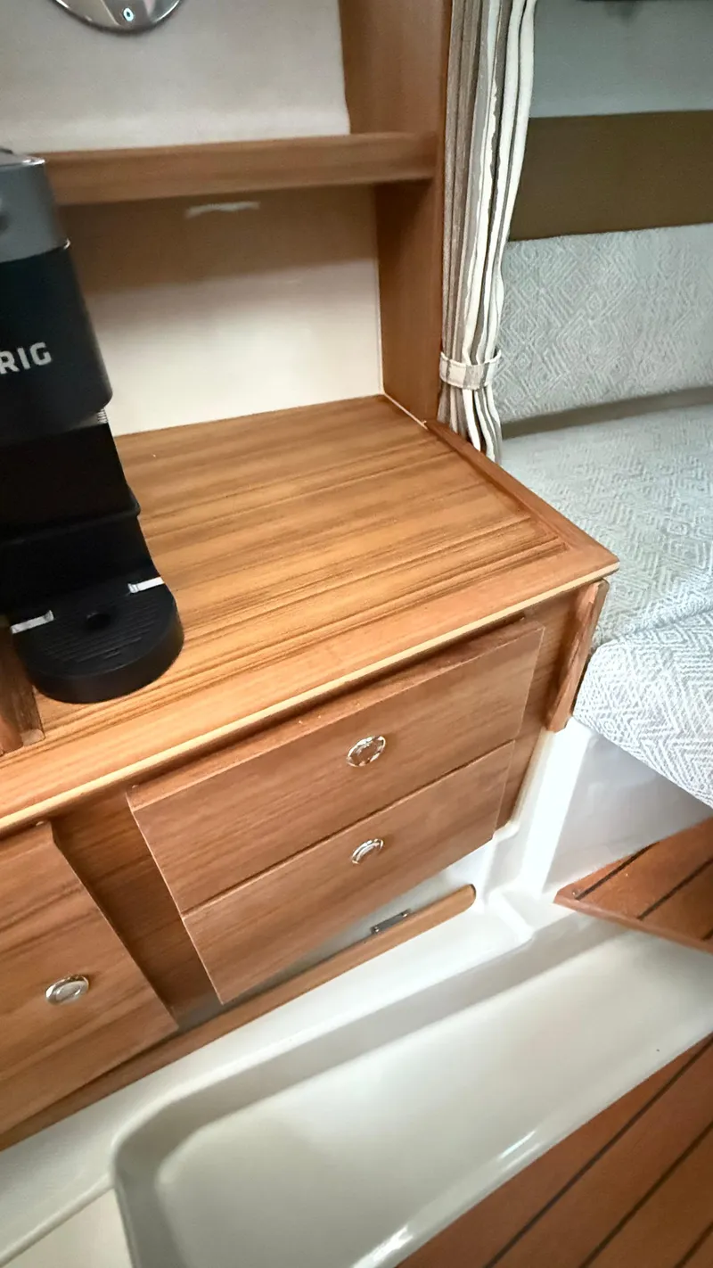 Slide: The Image of Interior of 2026 Ranger Tugs R-27, featuring wooden cabinetry and a cozy sleeping area. - 44