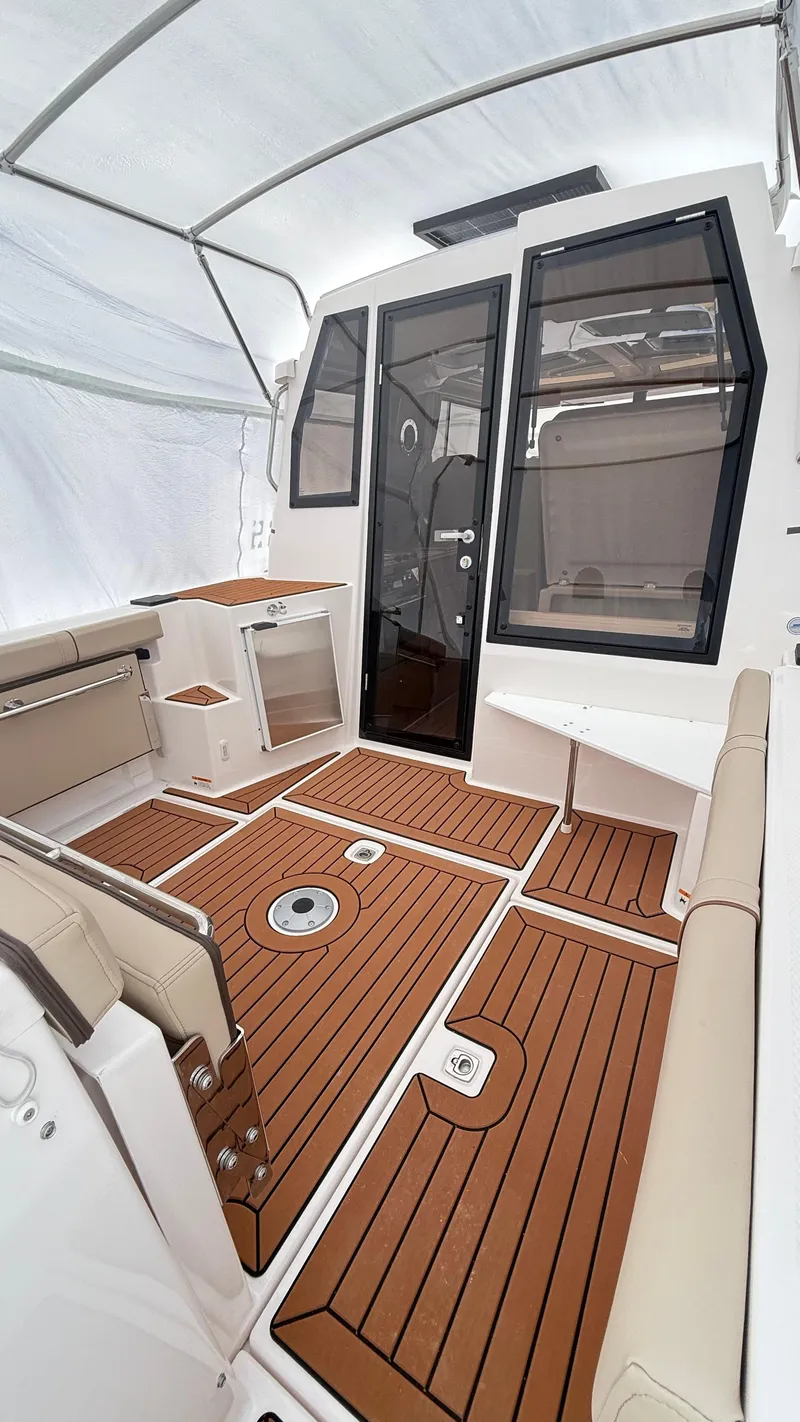 Slide: The Image of 2026 Ranger Tugs R-27 boat interior with teak flooring and modern seating. - 6