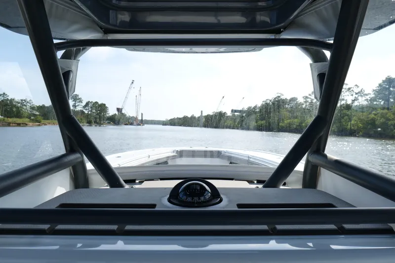 Slide: The Image of 2022 Yellowfin 34 Offshore boat navigating a scenic river with cranes in the background. - 11