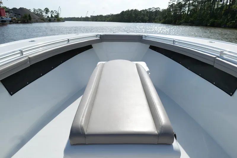 Slide: The Image of 2022 Yellowfin 34 Offshore boat interior with cushioned seating, on a calm river. - 21