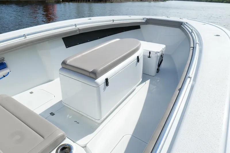 Slide: The Image of 2022 Yellowfin 34 Offshore boat interior with seating and storage, docked on calm water. - 22
