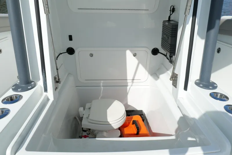 Slide: The Image of 2022 Yellowfin 34 Offshore boat interior with marine toilet and storage compartment. - 25