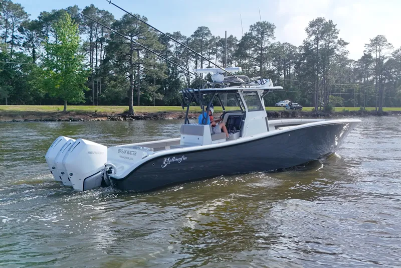 Slide: The Image of 2022 Yellowfin 34 Offshore boat cruising on a lake with trees in the background. - 6