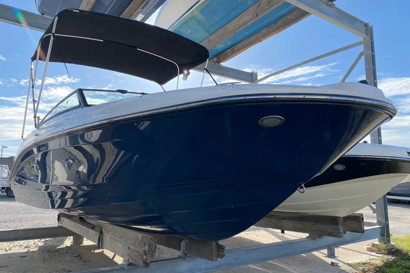 The Image of 2018 Sea Ray SPX 230 boat on a rack under a clear blue sky. - 0