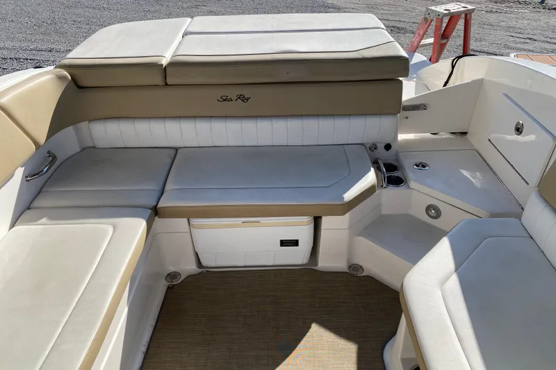 Slide: The Image of 2018 Sea Ray SPX 230 boat interior with beige and white cushioned seating. - 19