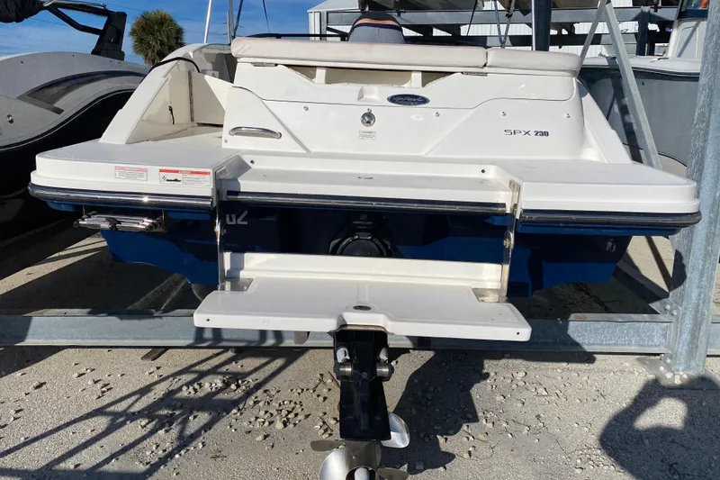 Slide: The Image of 2018 Sea Ray SPX 230 boat on a lift, featuring sleek design and outboard motor. - 4