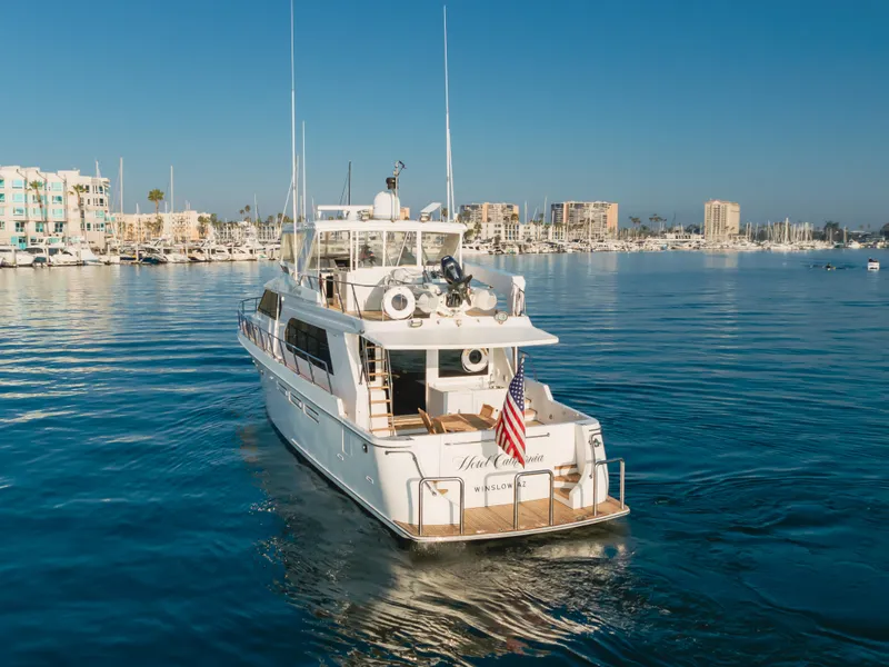 Slide: The Image of Ocean Alexander 64 Pilothouse yacht, 2003 model, cruising in a marina with cityscape background. - 11