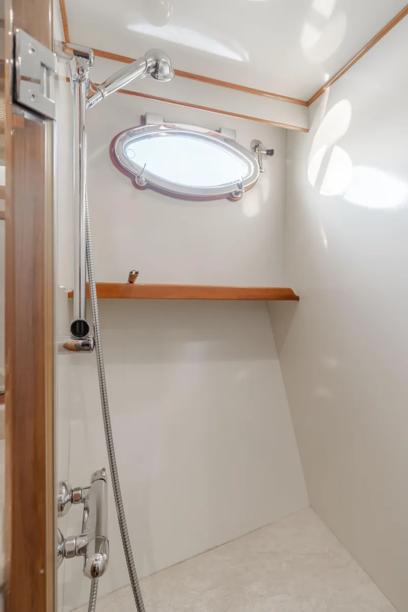 Slide: The Image of Shower area in 2003 Ocean Alexander 64 Pilothouse yacht with porthole and wooden shelf. - 28