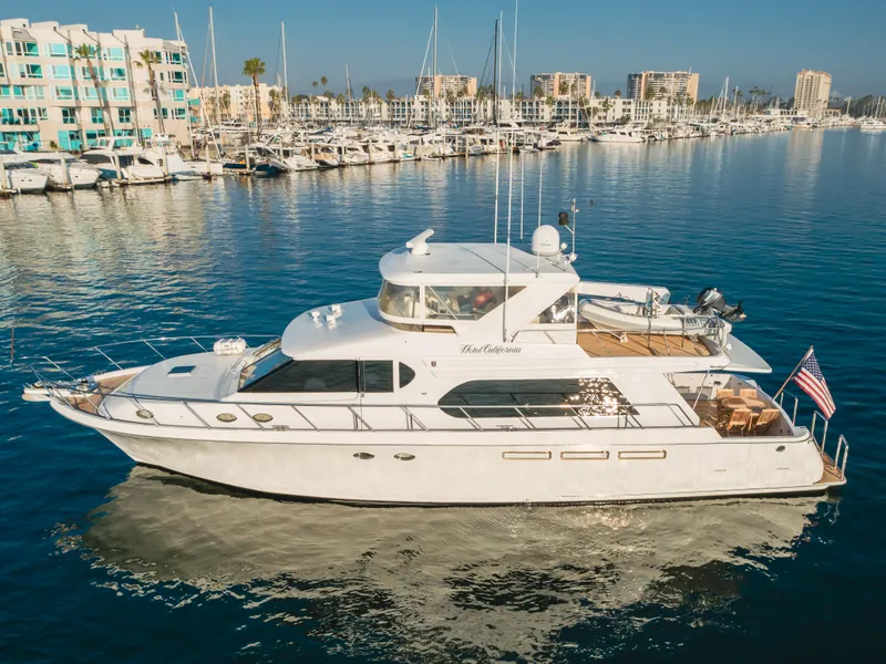 Slide: The Image of 2003 Ocean Alexander 64 Pilothouse yacht docked in a marina, calm waters, clear sky. - 5