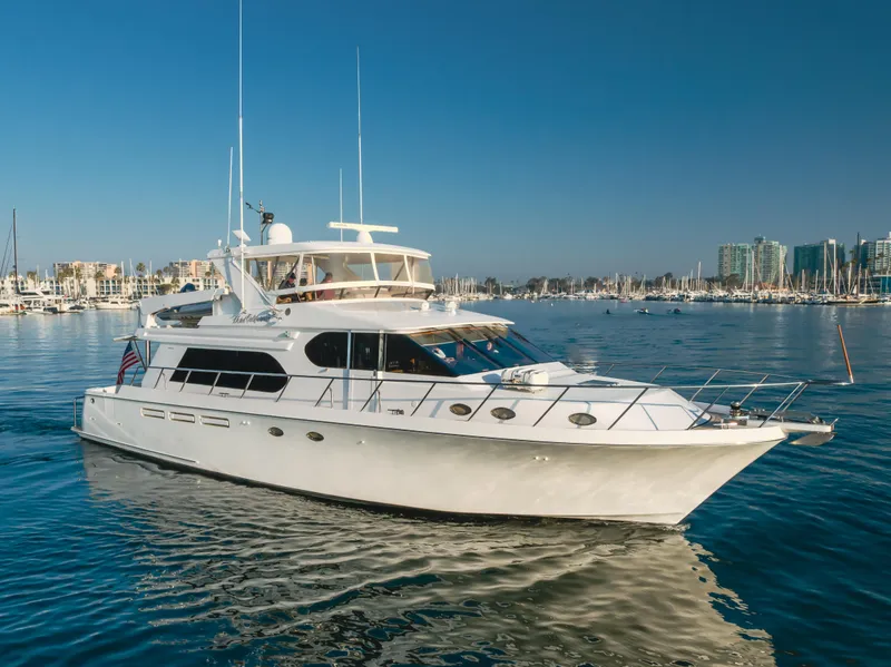 Slide: The Image of 2003 Ocean Alexander 64 Pilothouse yacht cruising in a marina with cityscape background. - 6