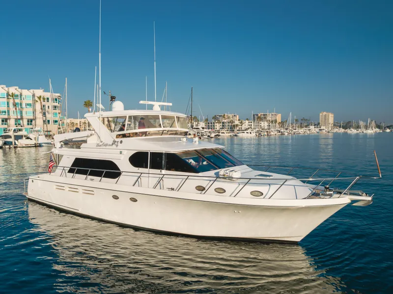 Slide: The Image of 2003 Ocean Alexander 64 Pilothouse yacht on calm water, marina in background. - 8
