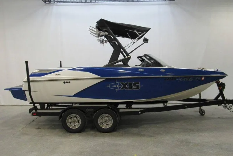 The Image of 2016 Axis A20 boat in blue and white on a trailer, side view. - 0