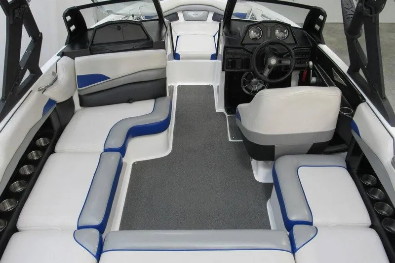 Slide: The Image of 2016 Axis A20 boat on trailer, blue and white design, indoor setting. - 3