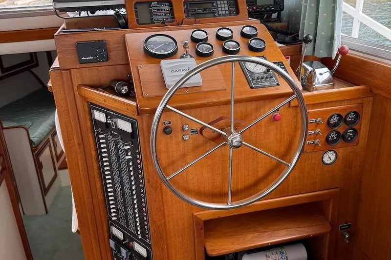 Slide: The Image of 1990 Nauset Flybridge Cruiser helm with gauges, steering wheel, and navigation equipment. - 10