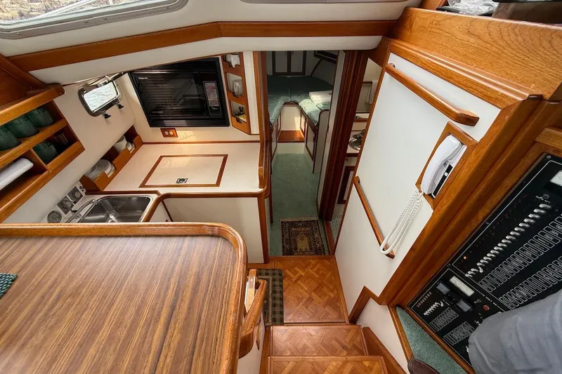 Slide: The Image of Interior of 1990 Nauset Flybridge Cruiser with wood accents and compact kitchen area. - 12