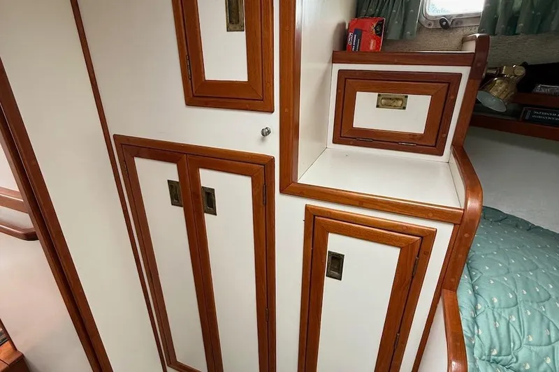 Slide: The Image of Interior of 1990 Nauset Flybridge Cruiser, featuring wooden cabinetry and cozy sleeping area. - 21