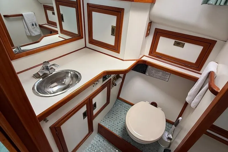 Slide: The Image of 1990 Nauset Flybridge Cruiser bathroom with wood trim, stainless steel sink, and compact toilet. - 22