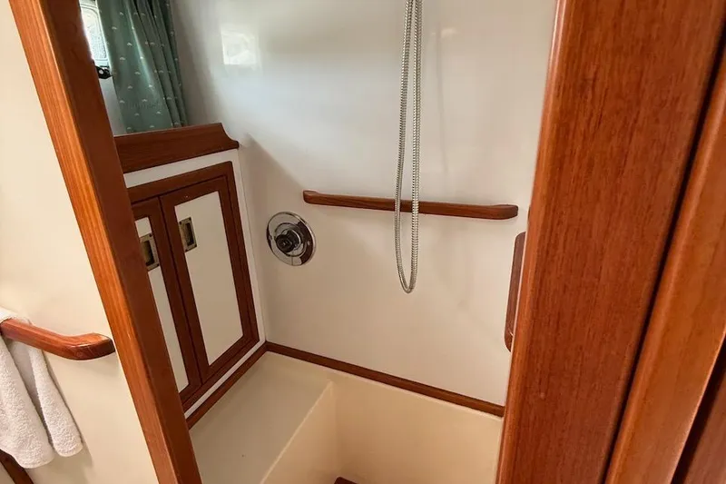 Slide: The Image of Shower area in 1990 Nauset Flybridge Cruiser with wooden accents and modern fixtures. - 23