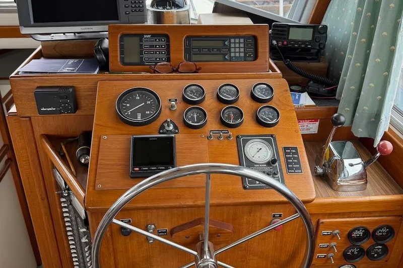 Slide: The Image of 1990 Nauset Flybridge Cruiser helm with gauges, controls, and navigation equipment. - 26