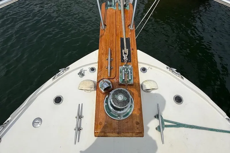 Slide: The Image of Bow of 1990 Nauset Flybridge Cruiser with wooden deck and nautical equipment. - 33