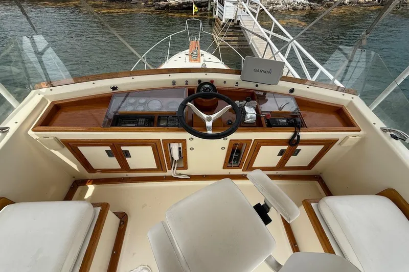 Slide: The Image of 1990 Nauset Flybridge Cruiser helm with Garmin GPS, wooden accents, and dual seating. - 39
