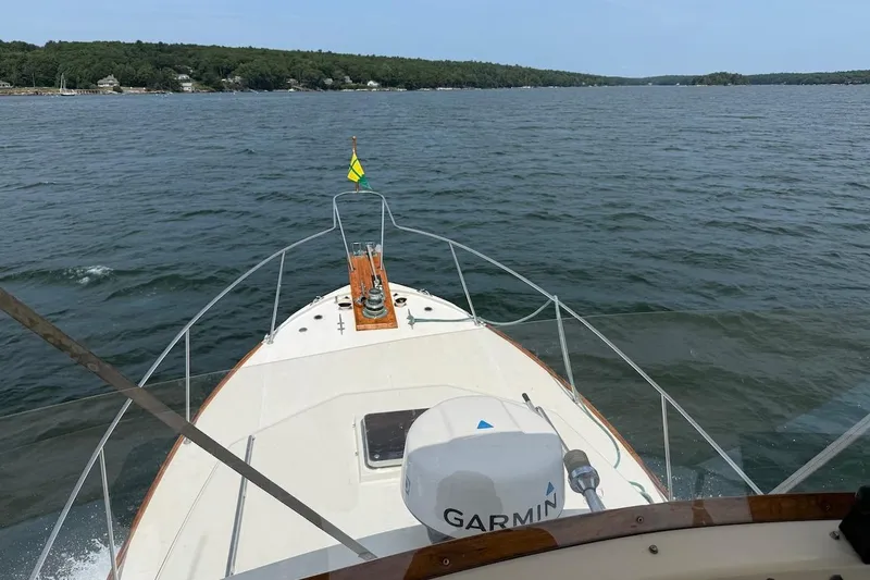 Slide: The Image of 1990 Nauset Flybridge Cruiser with extended hardtop on open water, featuring Garmin equipment. - 40