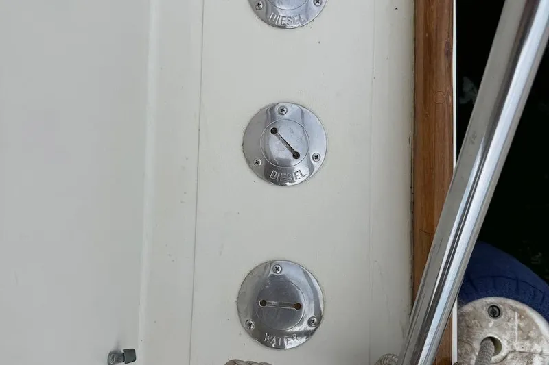 Slide: The Image of Fuel and water caps on a 1990 Nauset Flybridge Cruiser boat. - 44