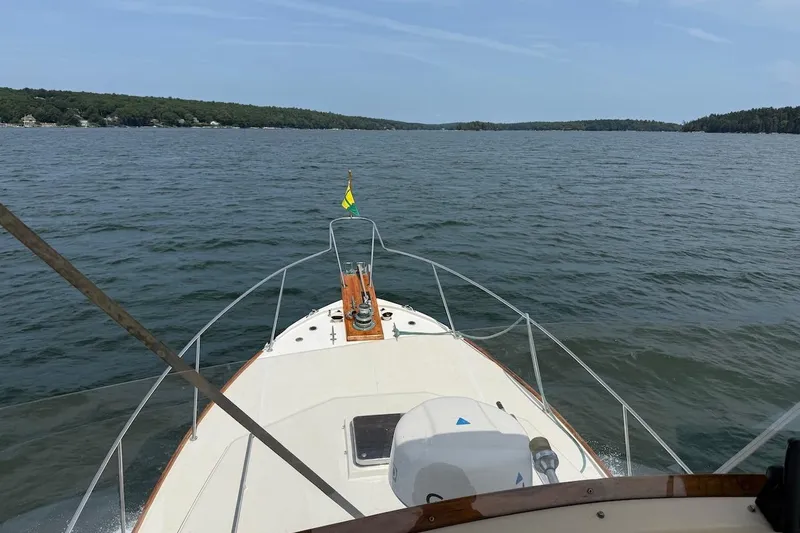 Slide: The Image of 1990 Nauset Flybridge Cruiser with extended hardtop on a serene lake. - 46
