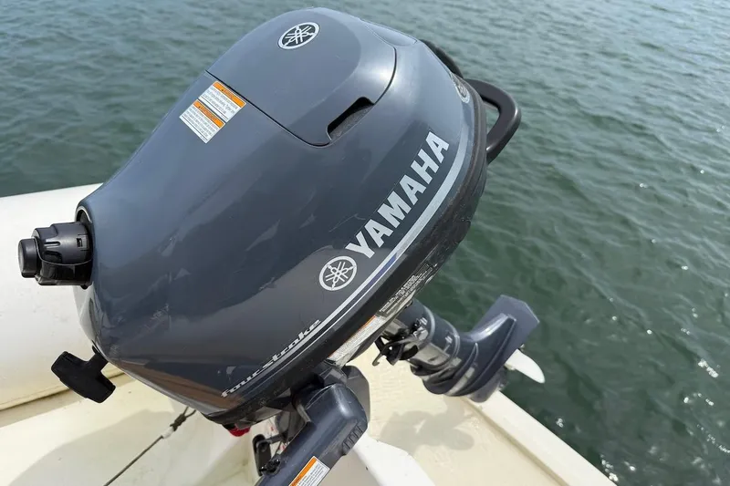 Slide: The Image of Yamaha outboard motor on Nauset Flybridge Cruiser, 1990 model, near water. - 52
