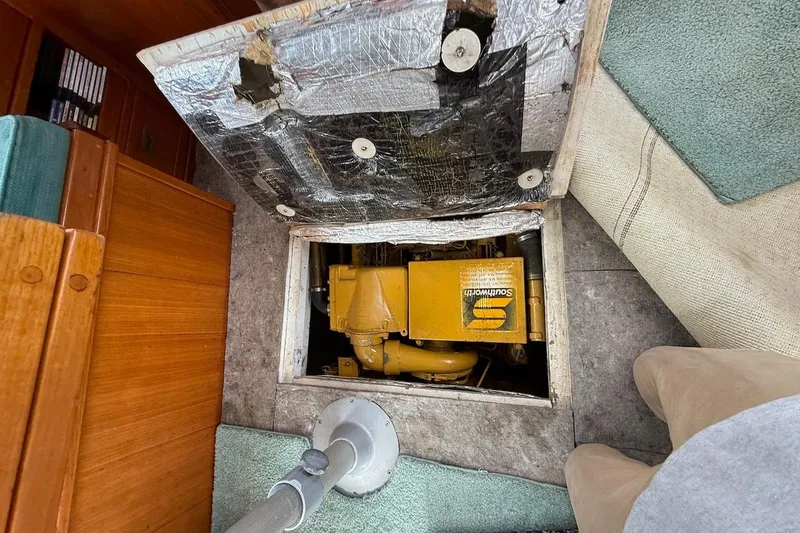 Slide: The Image of Engine compartment of 1990 Nauset Flybridge Cruiser with visible yellow machinery. - 55