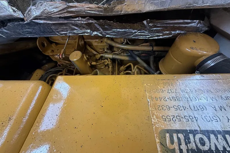 Slide: The Image of Engine compartment of a 1990 Nauset Flybridge Cruiser with Extended Hardtop, showing mechanical components. - 56