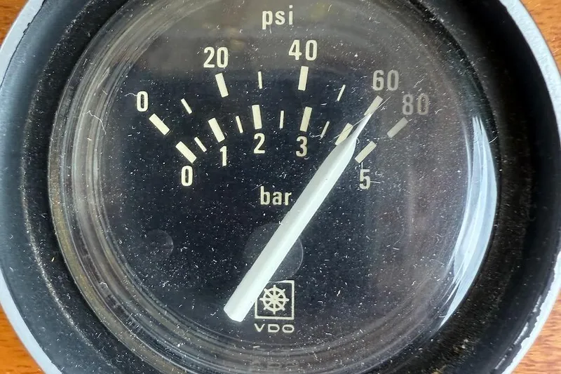 Slide: The Image of Close-up of a VDO pressure gauge showing psi and bar readings on a Nauset 1990 boat. - 59