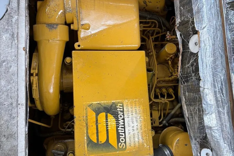 Slide: The Image of Yellow engine of a 1990 Nauset Flybridge Cruiser with Southworth branding. - 62