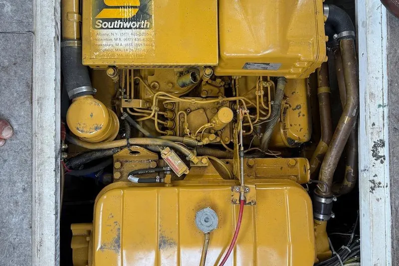 Slide: The Image of Yellow engine of a 1990 Nauset Flybridge Cruiser with Extended Hardtop, featuring Southworth branding. - 63