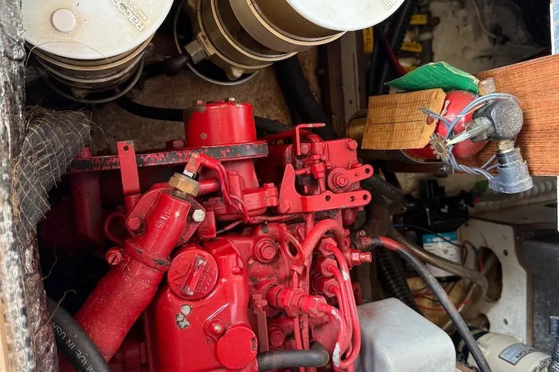 Slide: The Image of Engine compartment of a 1990 Nauset Flybridge Cruiser with red engine components. - 65