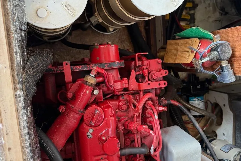 Slide: The Image of Engine compartment of a 1990 Nauset Flybridge Cruiser with red engine components. - 67