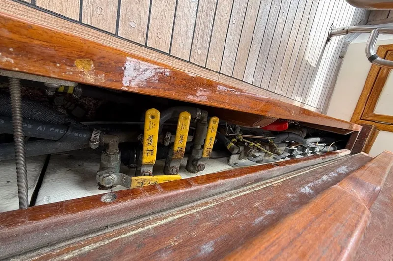 Slide: The Image of 1990 Nauset Flybridge Cruiser engine compartment with visible control levers and wooden deck. - 74